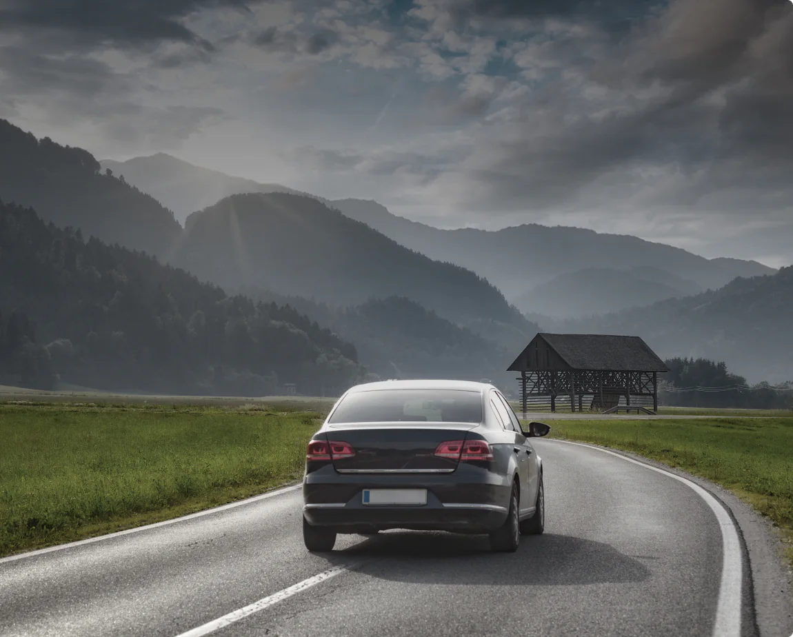 EV driving on rural road with Pion Power Flex-AC charger, supported by NEMA 5-15 and 14-50 adaptors for charging anywhere while traveling.